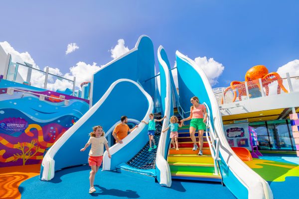 WN, Wonder of the Seas, family fun at Playscape, daytime, mother  and daughter on stairs, one child running, dad watching daughter on ropes, blue colors, octopus statue in right background,