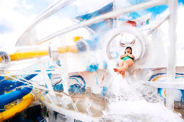 WN, Wonder of the Seas, woman smiling with delight as she comes out of the Perfect Storm water slide in a rush of water, fun, adventure,